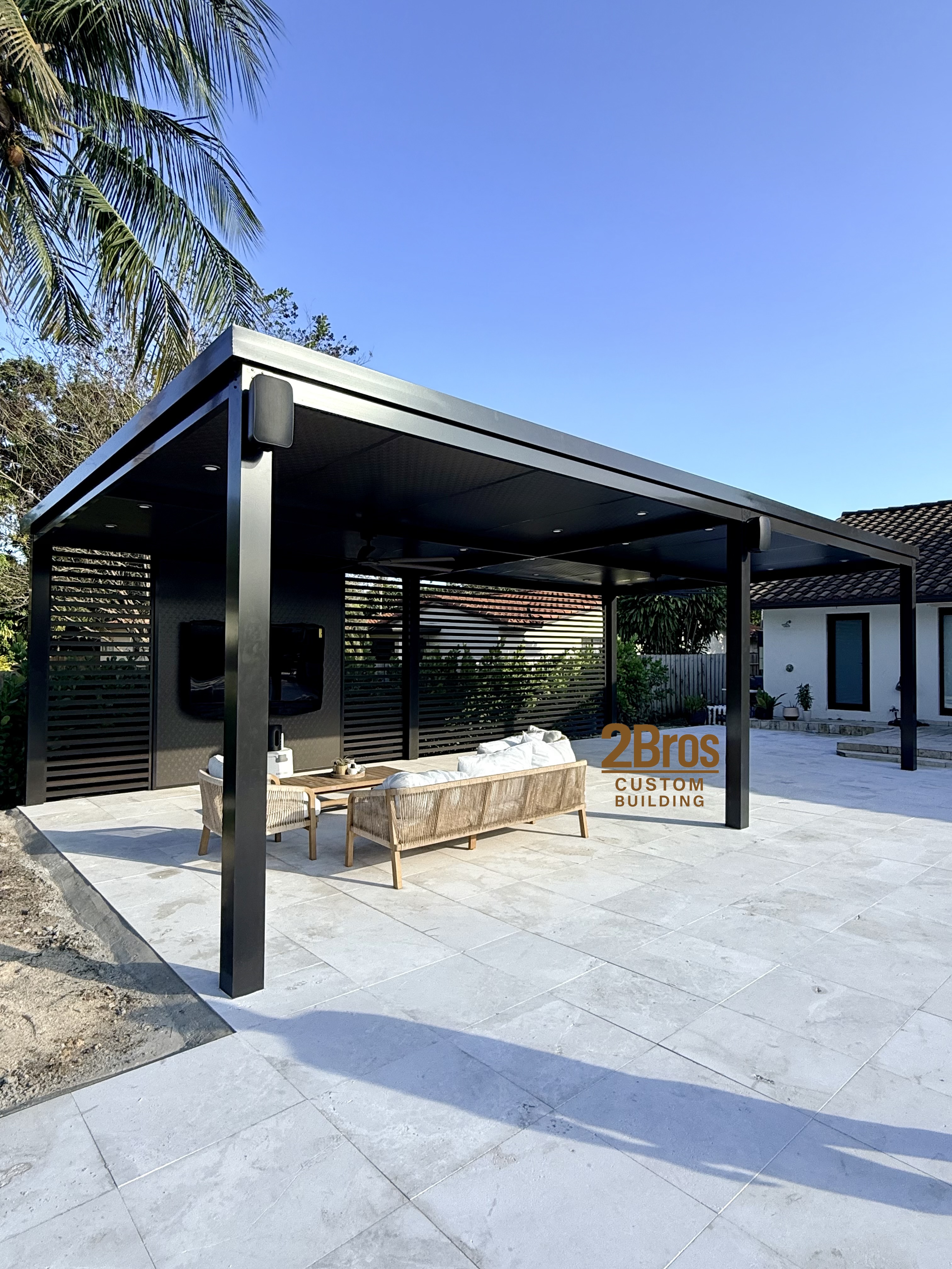 Dark pergola with louvered privacy walls and furnished outdoor living area